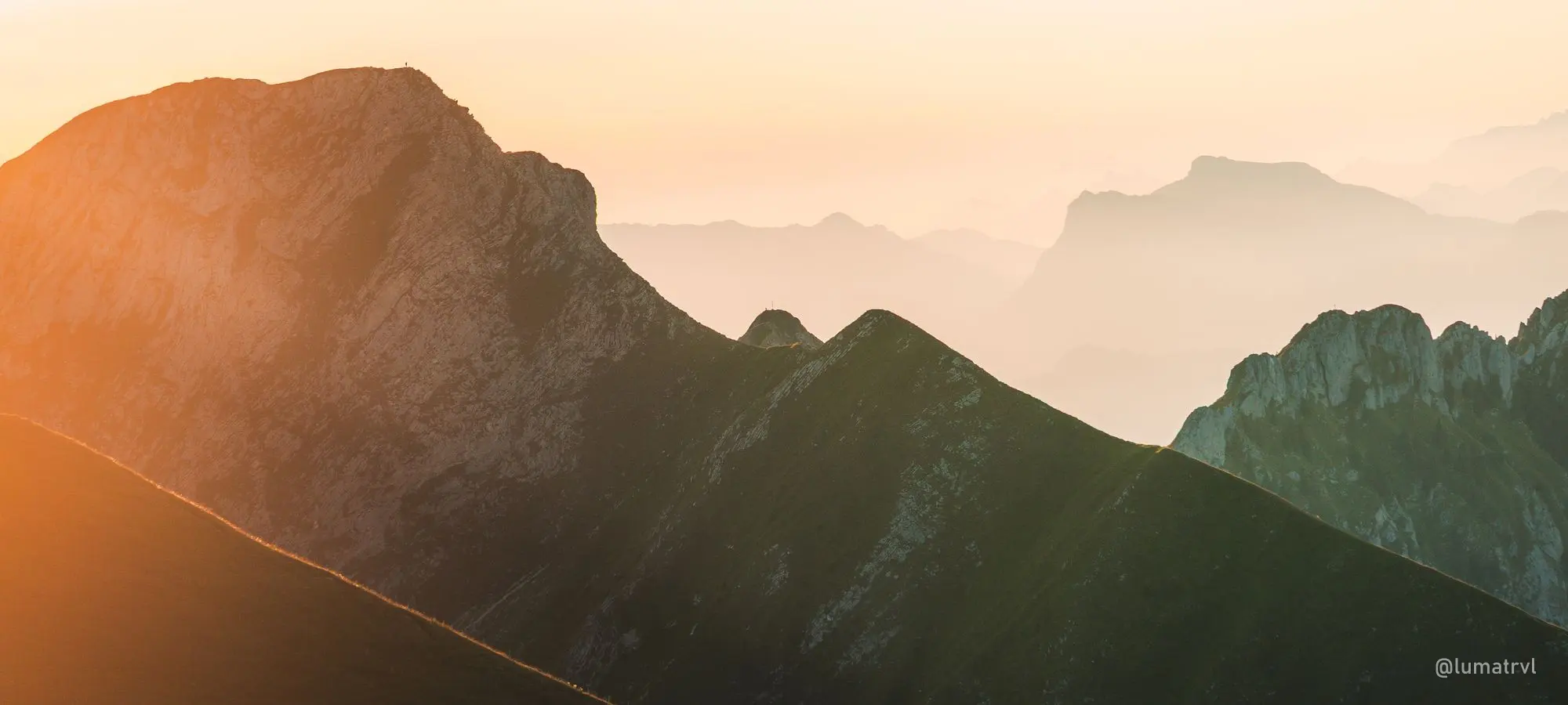 Layered mountain ridges in evening haze