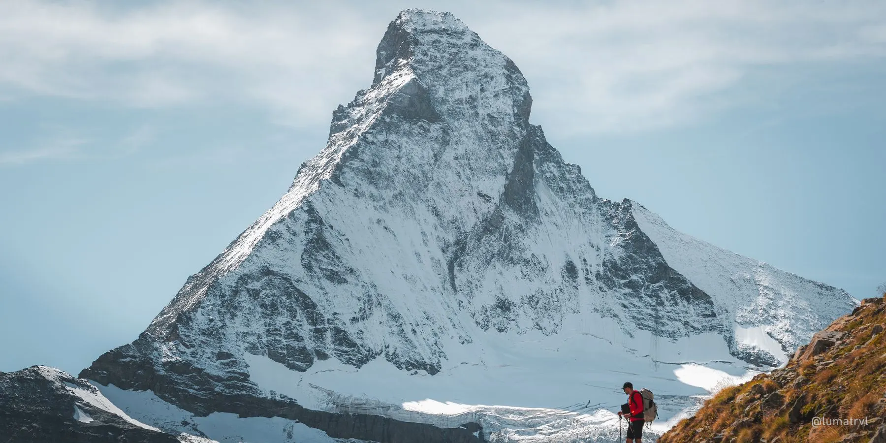A hiker below the Matterhorn on an autumn morning